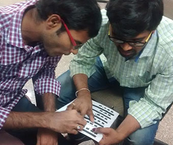 Trainer teaching a visually impaired participant desktop layout using tactile diagram